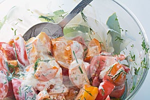 Tomato salad with sour cream and green dill in bowl with spoon. Healthy food concept