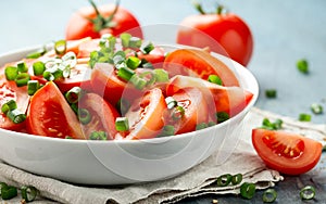 Tomato salad with spring onion and herbs in white bowl. Healthy summer food