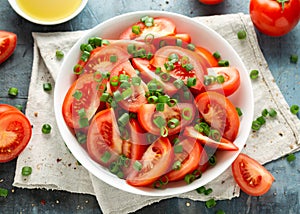 Tomato salad with spring onion and herbs in white bowl. Healthy summer food