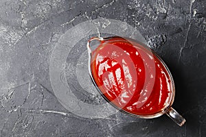 Tomato sauce in a gravy boat on a dark