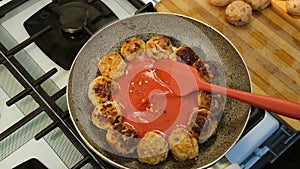 tomato sauce Pasta Poured On fried meatballs on frying pan