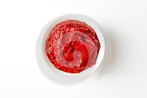 Tomato sauce in white bowl on white wooden