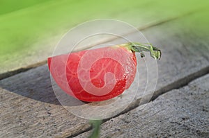 Tomato with slice on rustic wooden background. Fresh cut tomato  on wooden table