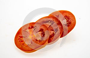 Tomato slices over a white background.