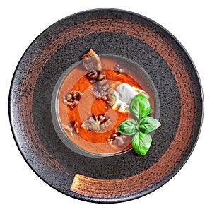 Tomato soup with crispy bacon with dollop of creamy mascarpone and basil above isolated