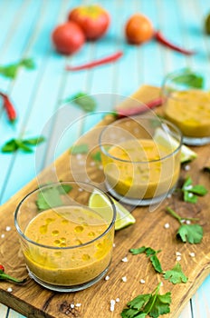 Tomato soup gazpacho and ingredients over turquoise wooden background