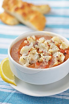 Turkish tomato soup with manty in a white bowl