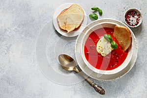 Tomato soup with mozzarella cheese, Basil and spices in a white plate. A thick, hearty dish, served with bread toast and olive oil