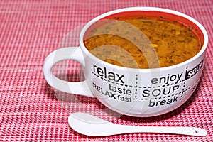 tomato soup in a mug on a red background top view