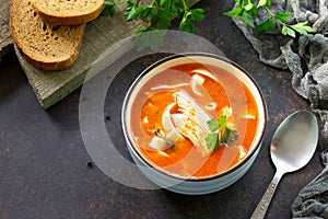 Tomato soup with pasta and chicken in a bowl on a dark stone background. The concept of healthy eating.