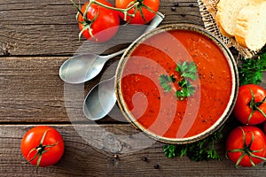 Tomato soup, top view, table scene on a wood background