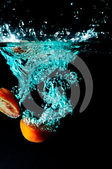 Tomato water splash on black background