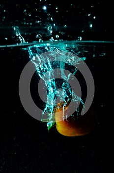 Tomato water splash on black background