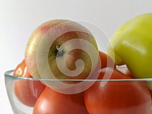 Tomatoes, an apple and sweet pepper in photo