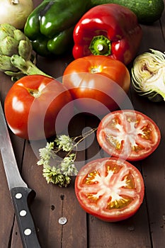 Tomatoes, bell peppers and artichoke with knife