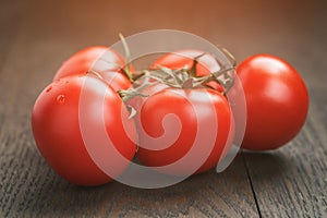 Tomatoes branch on wood table closeup