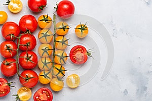 Tomatoes. Cherry tomato assortment, fresh red ripe on branch, red and yellow, whole and cut in half, on rustic table