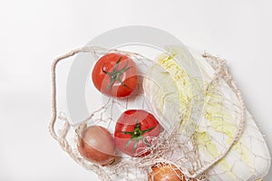 Tomatoes, chinese cabbage, onions in string bag on white background