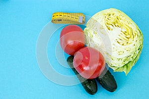 Tomatoes, cucumbers, cabbage and tape measure. The concept of proper nutrition to maintain beauty and health. Weight loss diet. Fl