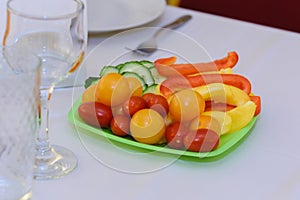 Tomatoes, cucumbers and peppers on the dining table.