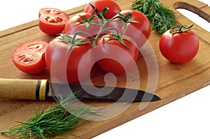 Tomatoes, dill and old knife on a cutting board on a white background