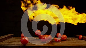 Tomatoes in fire. Vegetables throwing falling through fire