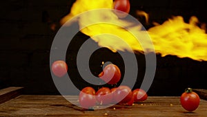 Tomatoes in fire. Vegetables throwing falling through fire