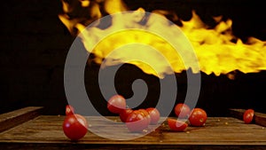 Tomatoes in fire. Vegetables throwing falling through fire