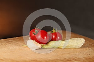 Tomatoes Garlic and Lettuce on Wood surface.