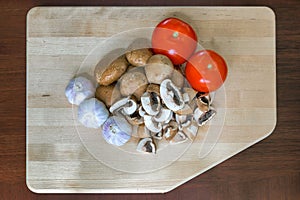 Tomatoes Garlic and Portobello Mushroom on Cutting Board