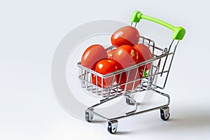 Tomatoes in a grocery cart. A shopping basket filled with fresh vegetables is isolated. The concept of healthy eating