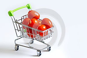 Tomatoes in a grocery cart. A shopping basket filled with fresh vegetables is isolated. The concept of healthy eating