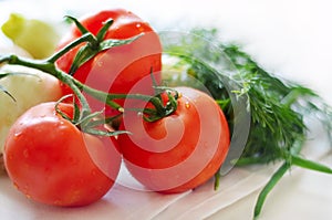 Tomatoes and herbs on a tablecloth. photo