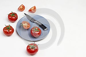 Tomatoes and knife on gray plate