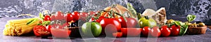 Tomatoes, Pasta, vegetables, herbs and spices for Italian food on rustic table