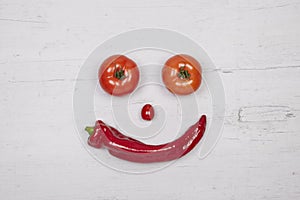 Tomatoes and pepperoni builting a face, copy space