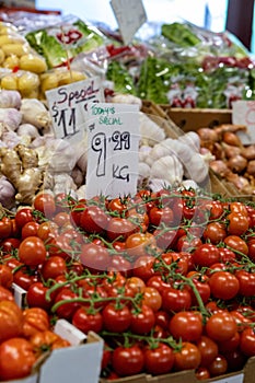 tomatoes on sale at an outdoor market area and vegetable stand