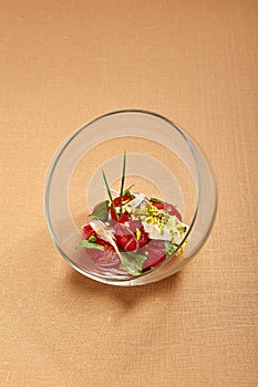 Tomatoes with stracciatella in round transparent glass bowl
