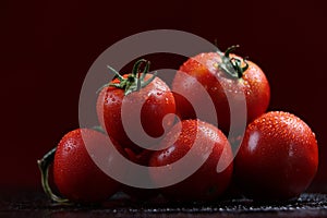 Tomatoes under water drops, red background