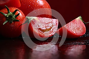 Tomatoes under water drops, red background