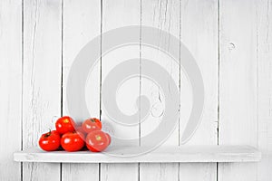 Tomatoes on a wooden shelf.