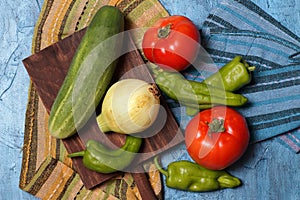 Tomatoes, zucchini, onion and pepper and wooden board photo