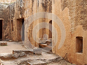 Tomb doors and niches in a carved sandstone wall forming a street like view in the temple of the kings area in paphos cyprus