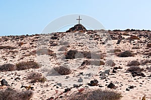 A tomb with a pile of stones and a wooden cross
