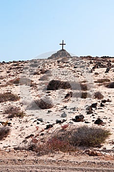 A tomb with a pile of stones and a wooden cross