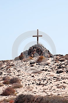 A tomb with a pile of stones and a wooden cross