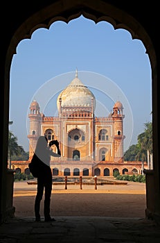 Tomb of Safdarjung seen from main gateway with silhouetted person taking photo, New Delhi, India
