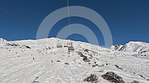 Tonale, Ponte di Legno, Italy. Chairlift with skiers moving to the top of the ski run in a wonderful sunny day