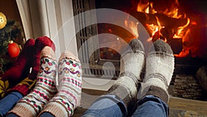 Toned closeup image of family warming feet at fireplace at night