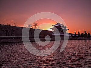Toned image of the fortress with a tower Forbidden City in Beijing on the background of sunset at clear sky